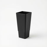 A Black Growers Plant Tube - 50mm, featuring a tall, matte black, square design, is shown against a plain white background.