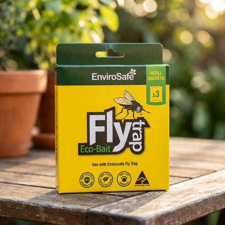 A box of Envirosafe Fly Attractant Refill - 3 Pack sits on a wooden surface outdoors.