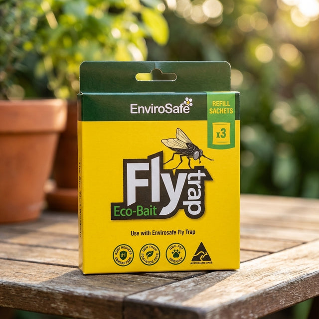 A box of Envirosafe Fly Attractant Refill - 3 Pack sits on a wooden surface outdoors.