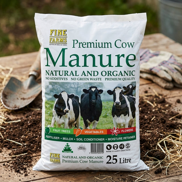 A Fine Farms 25L Cow Manure bag rests on a wooden surface next to a garden trowel.