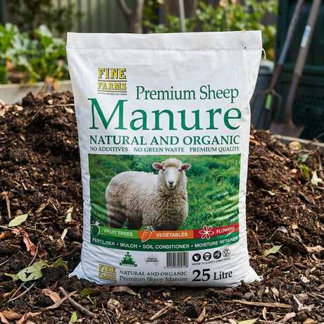 A 25L bag of Fine Farms Sheep Manure, a great organic soil conditioner, rests on a garden compost pile.