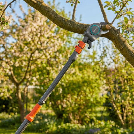 The GARDENA Tree Pruning Lopper trims branches in a sunny, blooming garden with its long reach.