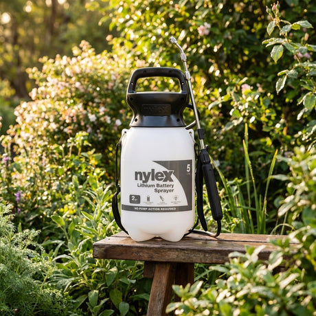 A Yates 200ml Zero Rapid Gel 1 Hour Action Weed Killer is loaded in a lithium battery sprayer on a sunlit garden bench, ready for precise weed control among lush plants.