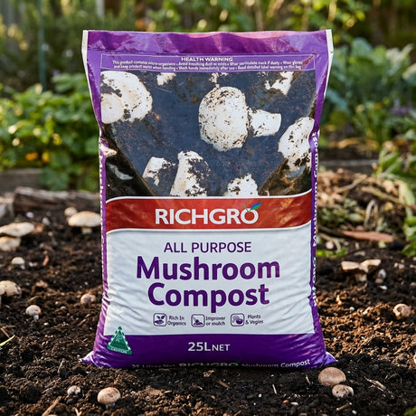 A 25L bag of Richgro 25L All Purpose Mushroom Compost, a premium soil conditioner, is standing on soil in a garden.