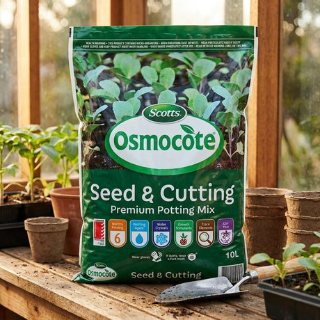 A bag of Scotts Osmocote 10L Seed And Cutting Premium Potting Mix rests on a wooden table, surrounded by seedlings and gardening tools—ideal for nurturing new growth.