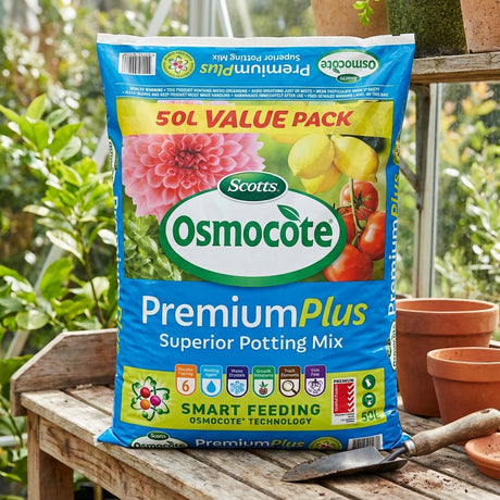 A bag of Scotts Osmocote 50L Premium Plus Superior Potting Mix sits on a table in a sunlit garden with plants and empty pots, offering water-saving technology and controlled-release feeding for healthy, thriving growth.