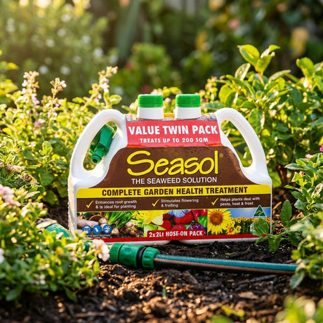 Seasol 2 x 2L Hose On Complete Garden Health Treatment Twin Pack shown on grass, with plants and a hose-on applicator in the background.