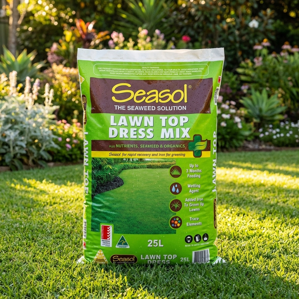 A bag of Seasol 25L Lawn Top Dress Mix rests on a manicured lawn, highlighting its quality lawn recovery blend, with a vibrant garden in the background.