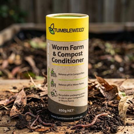 Tumbleweed Worm Farm And Compost Conditioner rests on soil with earthworms and dry leaves, helping maintain a healthy pH balance in your worm farm.