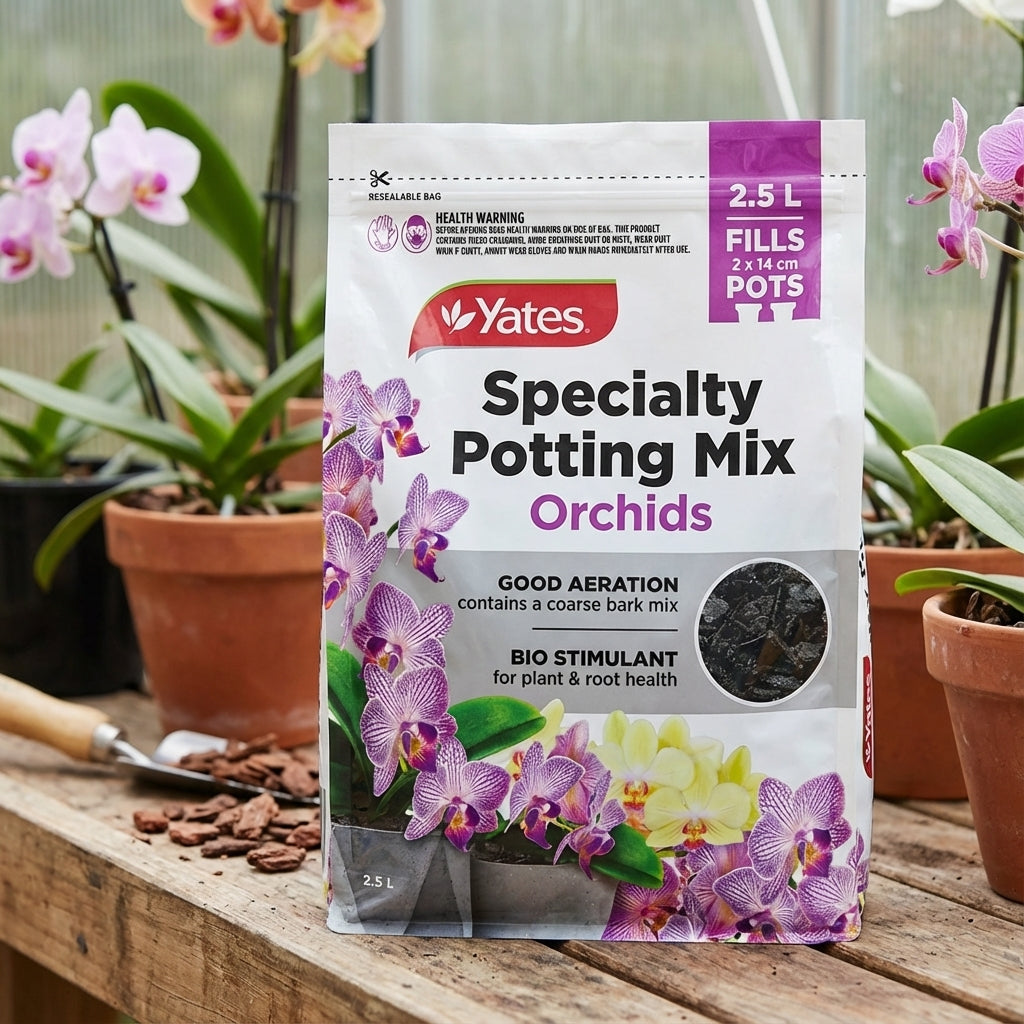 A bag of Yates 2.5L Specialty Potting Mix Orchids rests on a wooden table among potted orchids, its coarse bark blend perfect for healthy orchid roots.