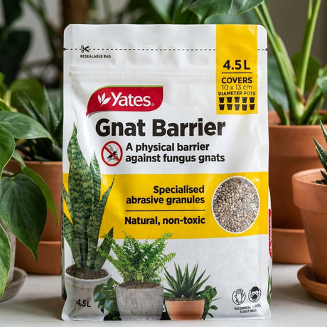 A bag of Yates 4.5L Gnat Barrier sits among potted plants, highlighting its natural pumice granules for effective fungus gnat control.