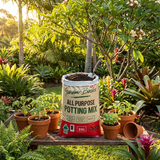 Garden Basics 25L All Purpose Potting Mix and potted plants on a wooden bench in a sunlit garden—ideal for excellent drainage in indoor and outdoor containers.
